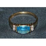 A blue topaz coloured and diamond 9ct five-stone ring, the central stone flanked by two small
