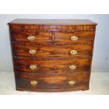 A George III mahogany Bow Front Chest of two short over three long cock beaded drawers, brass drop