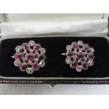 A pair of early 20th century, gold, diamond and ruby set screw back earrings, target style with