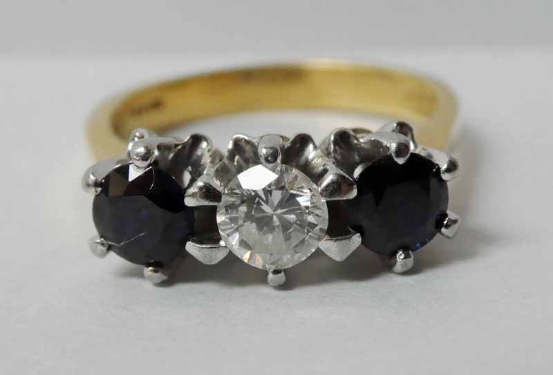 An 18ct gold three-stone sapphire and diamond Ring, central brilliant cut diamond approx 0.4ct