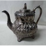 A Victorian silver Teapot of squat baluster four-footed form, heavily embossed with opposing fete
