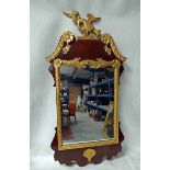 An Empire style mahogany and gilt crested wall mirror, surmounted by an eagle with prey, broken arch