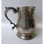 An early 20th century Silver One-Pint Tankard, baluster form on raised circular foot, S scroll
