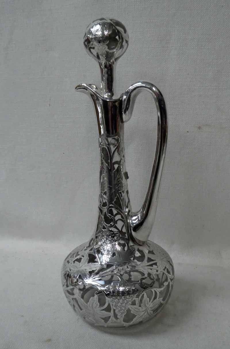 A continental Art Nouveau silver overlaid Claret Jug, typical form with overlaid pommel top stopper,