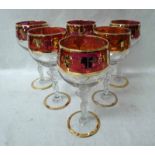 A set of six French Bayel Wine Glasses, ruby coloured and gilt grapevine highlighted bowl, supported