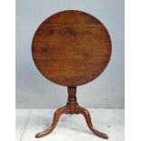 An early 19th century Yew flip top Tripod Table, hinged circular five plank top, turned support with