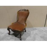 A reproduction Victorian style spoonback Nursing Chair, carved show frame with short crest,