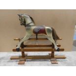 A painted rocking horse on mahogany base by Leo Stinchon of Bolton by Bowland, 151cm by 48cm by