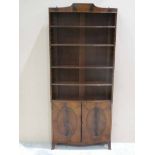 A Regency style mahogany open Bookcase, adjustable shelves over a two door cabinet, splayed legs,