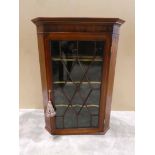A mahogany and line inlaid wall hanging Corner Cabinet, flat front with Astral glazed single door
