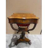 A Victorian Sewing Table, hinged inlaid top with serpentine front and canted corners opens to reveal
