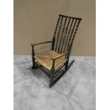 A Nursing Rocking Chair with barley twist back and rush seat