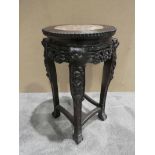 An early 20th century Chinese carved hardwood Jardiniere Stand, shaped and beaded circular top inset