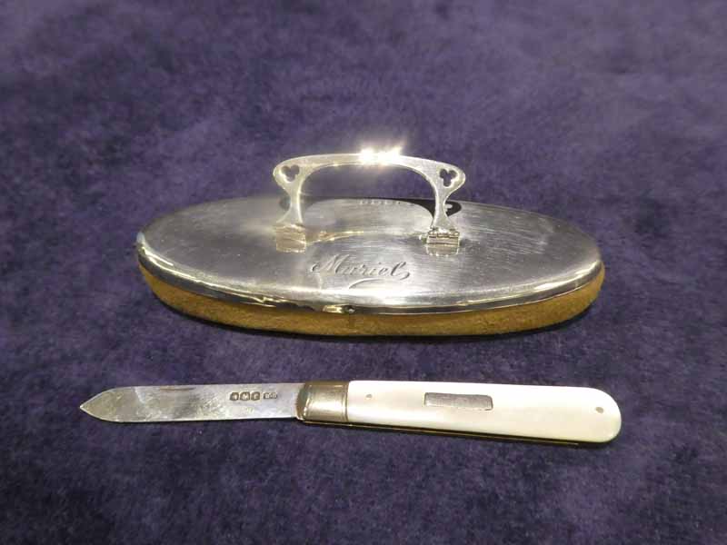 A silver backed Nail Buffer, boat shape with folding handle, inscribed Muriel, 11cm long and a