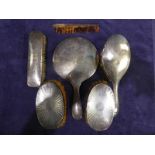 Six items of silver backed Dressing Table Ware, four brushes, hand mirror and comb, all bumped