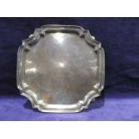 A mid 20th century silver four footed Salver, square with canted corners, raised rim on shallow ball