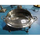 A silver plated Breakfast Dish with pierced liner ram's head supports on ball feet, 45cm wide by