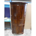 An early 19th century George III mahogany floor standing Corner Cabinet, bow fronted, two tier,