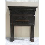 A heavily carved oak mantelpiece decorated with mythical figures, faces etc, small mantel shelf,