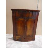 A 19th century Georgian mahogany wall hanging Corner Cabinet, bow fronted with applied carved