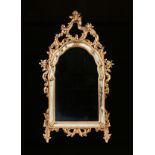 A GEORGE II STYLE CARVED AND PARCEL GILT WOOD MIRROR, 20TH CENTURY, with an arched and reticulated