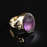 A YELLOW GOLD AND AMETHYST MEN'S SIGNET RING, the oval stone carved crest with bishops mitre, shell,