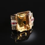 A LARGE ART MODERNE HONEY YELLOW CITRINE, DIAMOND, AND RUBY YELLOW GOLD RING, centering a step cut