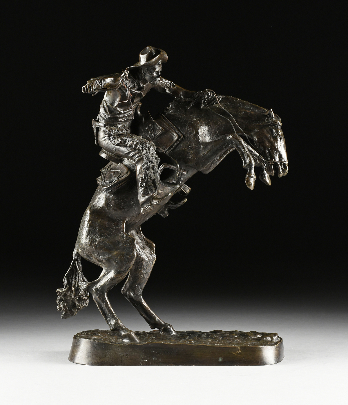 FREDERIC REMINGTON (American 1861-1909) A BRONZE SCULPTURE, "Bronco Buster," with dark brown