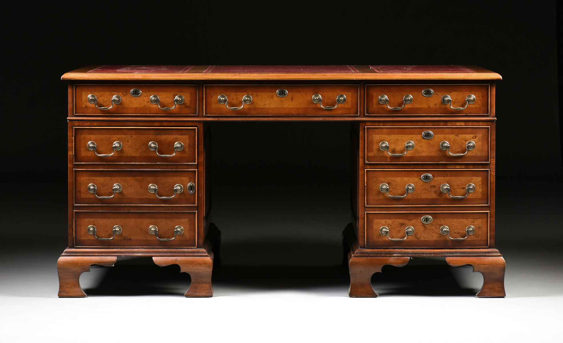 A GEORGE II STYLE WALNUT BURGUNDY LEATHER TOP PARTNER'S DESK, ENGLISH, MID 20TH CENTURY, modeled