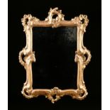 AN ITALIAN ROCOCO REVIVAL GILTWOOD MIRROR, LATE 19TH CENTURY, with an "antiqued" rectangular