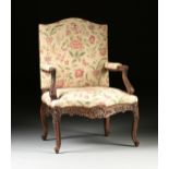 A RÉGENCE STYLE UPHOLSTERED AND CARVED OAK HIGH BACK FAUTEUIL, LATE 19TH CENTURY, with a tall