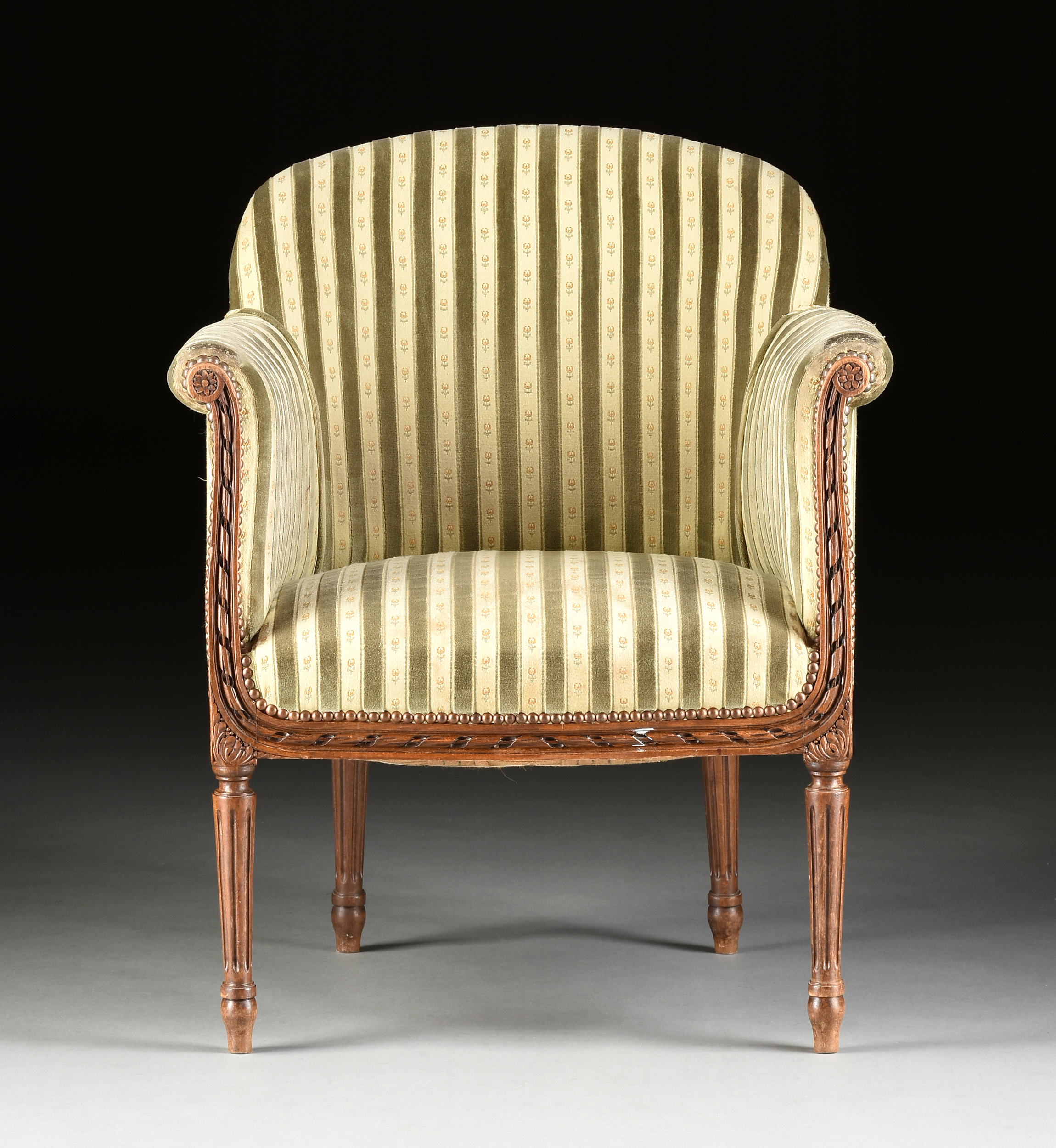 AN ELEGANT LOUIS XVI REVIVAL UPHOLSTERED AND CARVED WALNUT BERGÉRE EN GONDOLE, EARLY 20TH