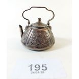 A Dutch white metal miniature kettle with foliage decoration 4cm tall