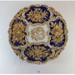 A large Meissen gilt and cobalt blue plate on a wooden framed base 31cm diameter