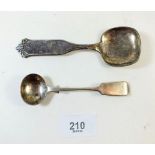 A silver salt spoon and a white metal continental caddy spoon