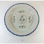 A late 18th/early 19th century creamware pottery charger with blue border and floral decoration -