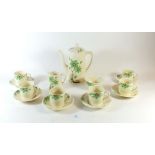 An Art Deco coffee set painted green flowers comprising: coffee pot, six cups and saucers, milk