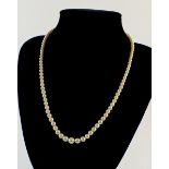 A graduated string of pearls with silver clasp