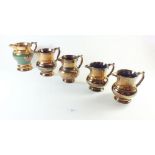 A set of five copper lustre jugs