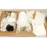 A box of assorted textiles and accessories including wedding veils, lace babies bonnets etc