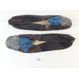 A pair of late 18th/early 19th century leather slippers with embroidered decoration and blue silk