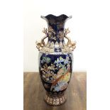 A tall oriental style vase decorated flowers and birds