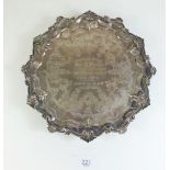 A small silver salver on scroll feet and rococo style border, engraved to centre: 'Presented to