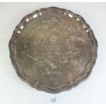A silver salver standing on three scroll feet with scallop edge. From the crew of the Royal