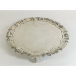 A silver pie crust edge salver on scroll feet - 26cm dia, by William Hutton and Sons, London