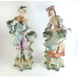A pair of continental bisque figures of grape pickers - 40cm