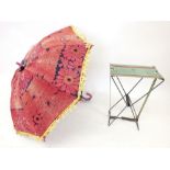 An Indian embroidered fabric parasol and a small folding stool