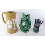 An Adams brown stoneware jug with applied vine decoration, a Dartmouth fish jug and a blue Studio