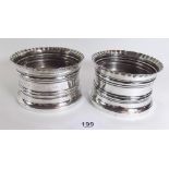 A pair of silver bottle coasters with frilled tops and wooden inset bases, Chester 1908
