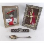 Two silver photograph frames, one with embossed decoration 16 x 11cm, a white metal comb frame and a